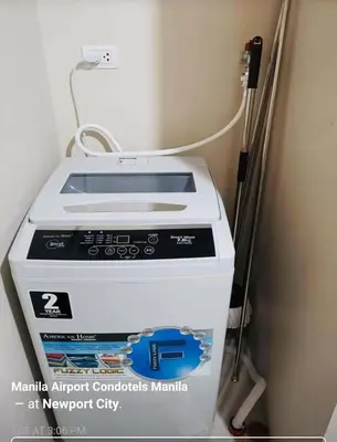 a washing machine is sitting in a room at Condo Apartment near Manila Airport NAIA T3 in Manila