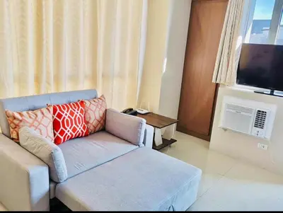 a living room with a couch and a flat screen tv at Condo Apartment near Manila Airport NAIA T3 in Manila