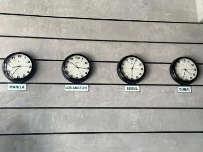 four clocks on a wall with different time zones at DG Budget Hotel Salem in Manila