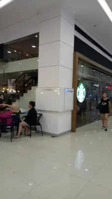 two women sitting in chairs in a shopping mall at Jazz Residences Condo in Manila