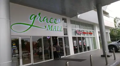 a man standing outside of a pizza mall at Cozy 1BR-Grace Residences in Manila