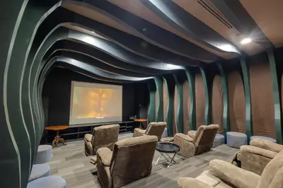 a cinema room with chairs and a large screen at The Alpha Suites in Manila
