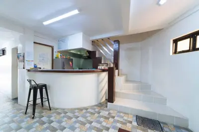 a kitchen with a counter and a bar with a stool at RedDoorz at San Antonio Binan Laguna in Biñan