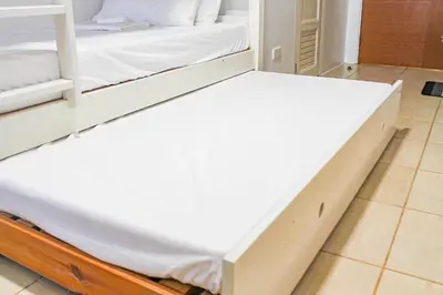 a bed frame in a room with a white mattress at Titan Condo at Studio City Tower 3 Alabang in Manila