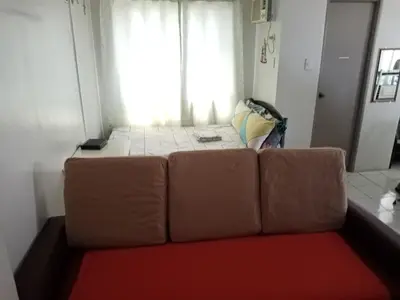 a brown couch in a room with a window at Spacious Studio unit beside Enchanted Kingdom at Santa Rosa City Laguna in Santa Rosa