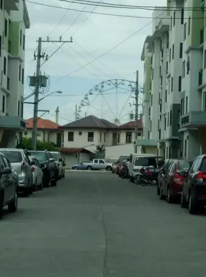 a parking lot with a ferris wheel in the background at Spacious Studio unit beside Enchanted Kingdom at Santa Rosa City Laguna in Santa Rosa