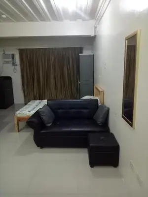 a living room with a couch and a bed at Vimelzu Mhavic Family Room in Manila