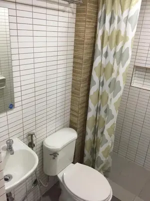 a bathroom with a white toilet and a sink at 1 River Central Hostel in Manila