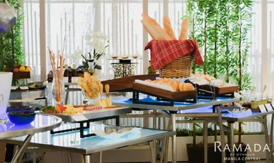a buffet with several tables with different types of food at Ramada by Wyndham Manila Central in Manila