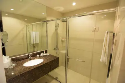 a bathroom with a sink and a glass shower at Ramada by Wyndham Manila Central in Manila
