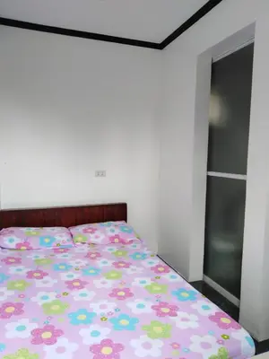 a bedroom with a bed with a floral bedspread at Diaz Residence in Silang