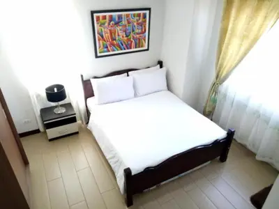 a bedroom with a white bed and a window at 1BR and Studio Condo Unit @ 150 Newport near NAIA 3 in Manila
