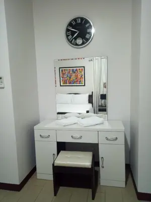 a white desk with a clock on a wall at 1BR and Studio Condo Unit @ 150 Newport near NAIA 3 in Manila