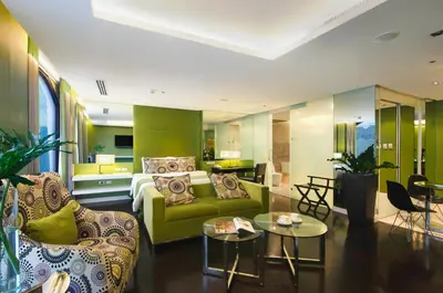 a living room with a green couch and a table at The Bayleaf Intramuros in Manila