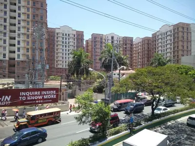 a city street with cars and buses and buildings at 2BR avida tower near NAIA airport in Manila