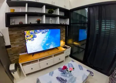 a living room with a flat screen tv and a window at Lotus Residence, Manila in Manila