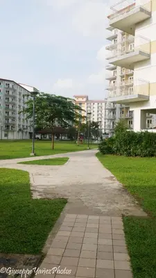 a walkway in a park next to a building at Genesis unit SMDC Fields in Manila