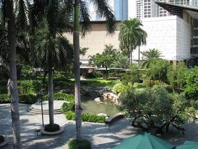 a view of a park with a pond and trees at Amora Suites at the Beacon Makati in Manila