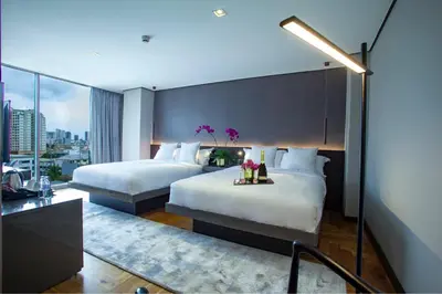 two beds in a hotel room with a view at Ramada Encore by Wyndham Makati in Manila