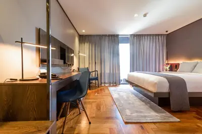 a hotel room with a bed and a desk at Ramada Encore by Wyndham Makati in Manila