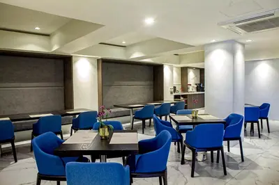 a dining room with blue chairs and tables at Ramada Encore by Wyndham Makati in Manila