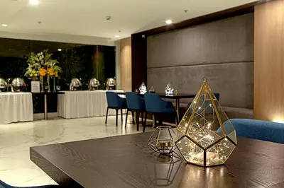 a dining room with a table and blue chairs at Ramada Encore by Wyndham Makati in Manila