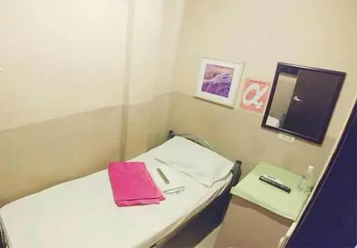 a small room with a bed with a pink bag on it at Amax Inn Makati in Manila