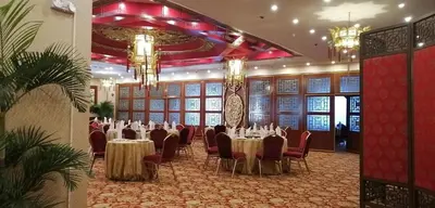 a banquet hall with tables and chairs and chandeliers at Manila Prince Hotel in Manila