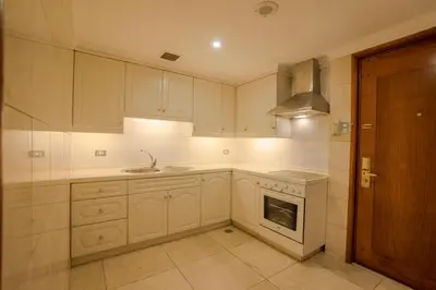 a kitchen with white cabinets and a sink and a stove at Manila Prince Hotel in Manila