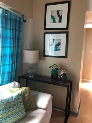 a living room with a couch and a table with a lamp at Loft condo beside Shangri-La Fort in Manila