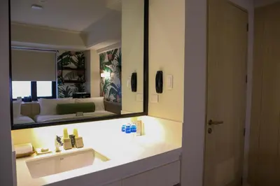 a bathroom with a sink and a large mirror at Mella Hotel Manila near NAIA Airport in Manila