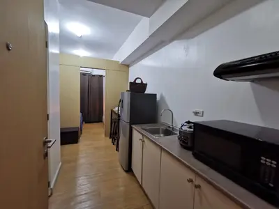 a small kitchen with a sink and a refrigerator at Liam's Pad at grace residences in Manila