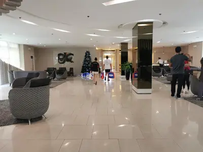 a lobby with a christmas tree and people walking in a building at Liam's Pad at grace residences in Manila