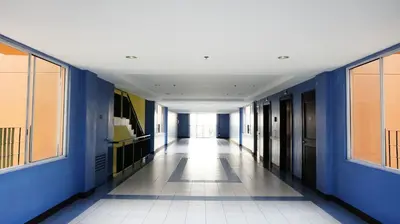 a hallway with blue walls and a white tile floor at 1BR with Balcony Overlooking Pool Chateau Elysee Near NAIA in Manila