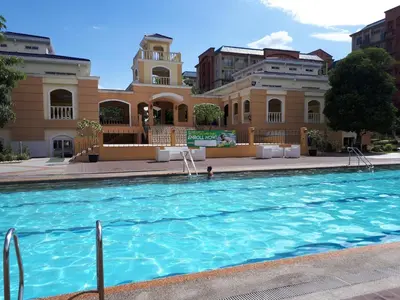 a large swimming pool in front of a building at 1BR with Balcony Overlooking Pool Chateau Elysee Near NAIA in Manila