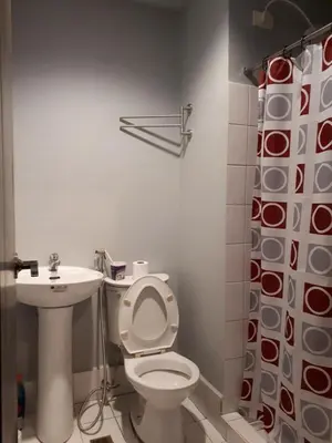 a bathroom with a toilet and a sink at 1BR with Balcony Overlooking Pool Chateau Elysee Near NAIA in Manila