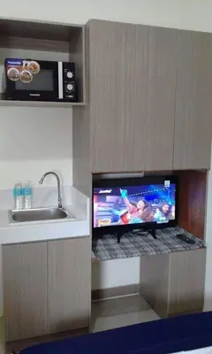 a kitchen with a sink and a tv on a counter at Mandaluyong Stays Inn in Manila