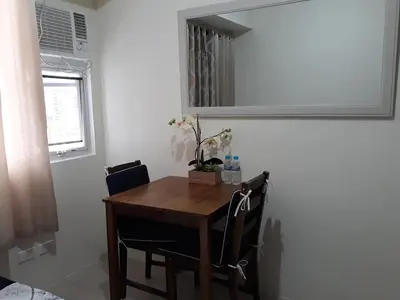 a dining room table with two chairs and a mirror at Mandaluyong Stays Inn in Manila