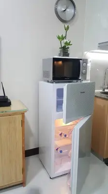 a kitchen with a microwave on top of a refrigerator at 101 Newport Boulevard C3 in Manila