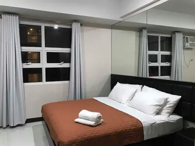 a bedroom with a bed with two towels on it at 101 Newport Boulevard C3 in Manila
