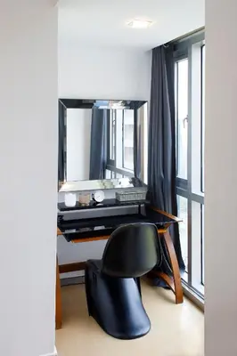a black chair in front of a desk with a mirror at Prime Avant BGC Location Apartments by PH Staycation in Manila