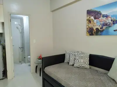 a bedroom with a couch and a painting on the wall at One Palm Tree Villas close to Manila Airport - Terminal 3 in Manila