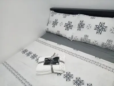 a white bed with a black and white snowflake bedspread at Flat NAIA Manila Chateau Elysee pool view in Manila