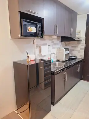 a kitchen with a sink and a microwave at Flat NAIA Manila Chateau Elysee pool view in Manila