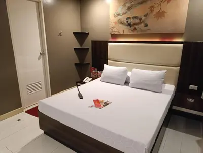 a bedroom with a large bed with white sheets at Hotel Sogo Malate in Manila