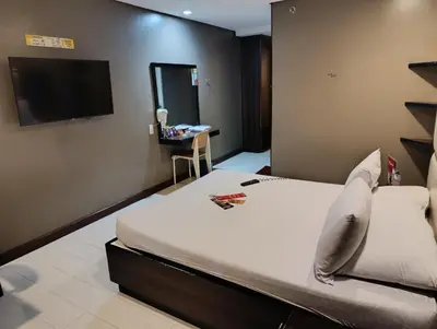 a hotel room with a bed and a flat screen tv at Hotel Sogo Malate in Manila