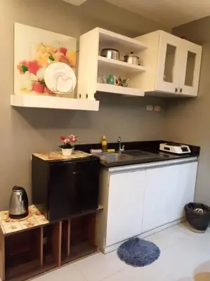a small kitchen with white cabinets and a sink at Kassel Dorz Hostel in Manila