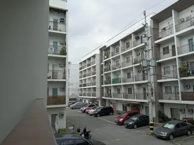 a parking lot in front of a large apartment building at Kassel Dorz Hostel in Manila