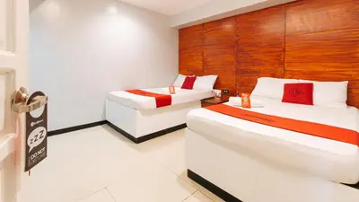 a hotel room with two beds and a chair at RedDoorz near Bambang Station in Manila