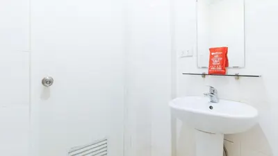 a white bathroom with a sink and a mirror at RedDoorz near Bambang Station in Manila